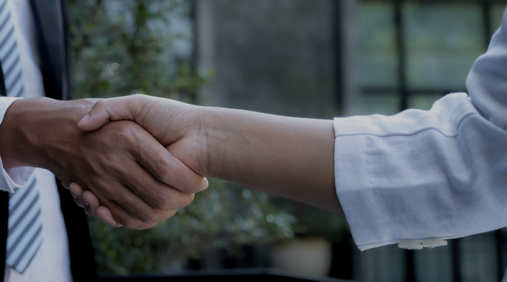 Two professionals shake hands to finalize an equipment financing agreement