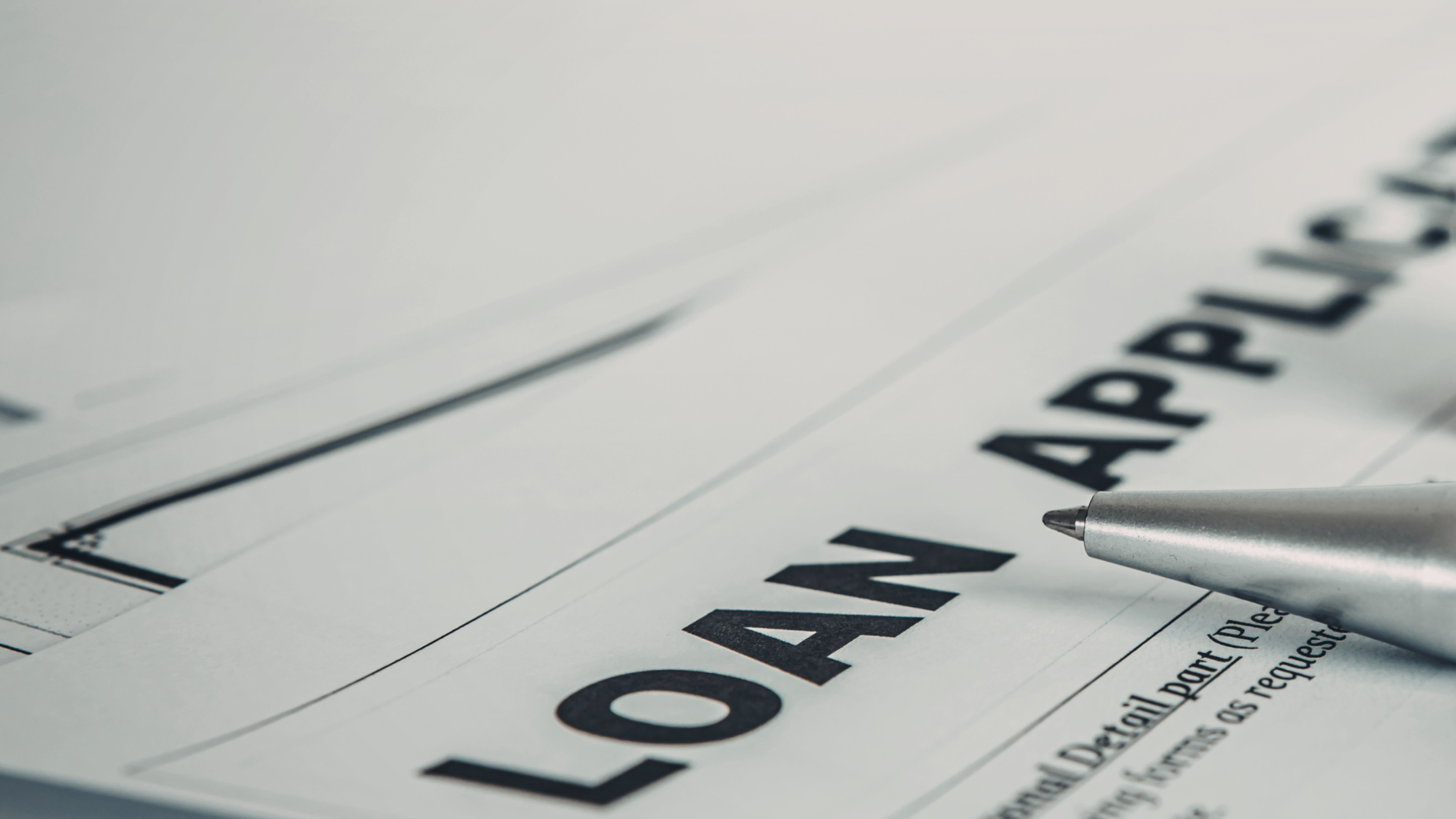 Loan Application form with a silver pen resting on the document.